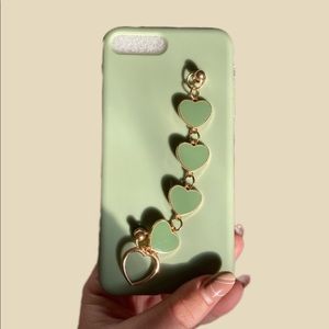 • mint green phone case, with a gold chain outline on dark green hears.